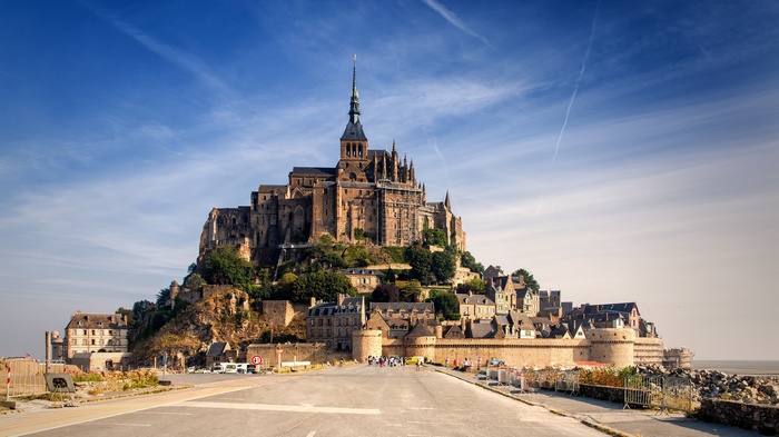 Mont Saint-Michel castle on a rocky island under a blue sky