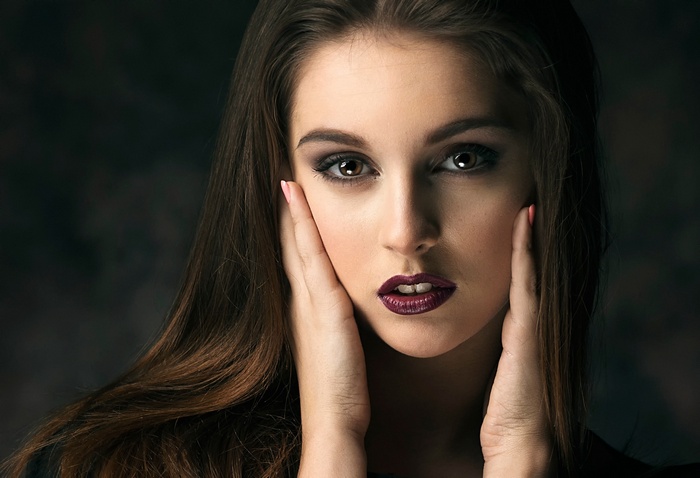 Portrait of a young woman with dark hair and makeup
