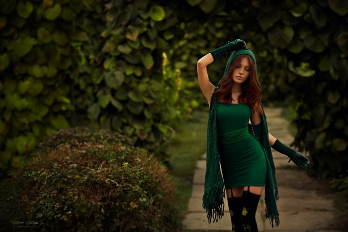 Woman in green dress and scarf in a garden