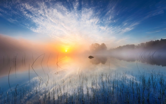 Misty sunrise over a lake in Sweden