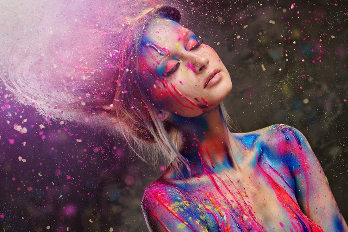 Woman covered in colorful paint splatters