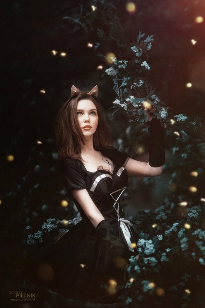 Woman with cat ears in a dark forest with lights