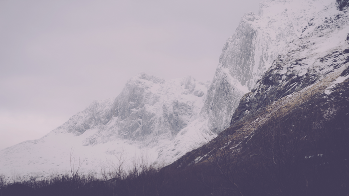 Snow-covered mountains under a cloudy sky