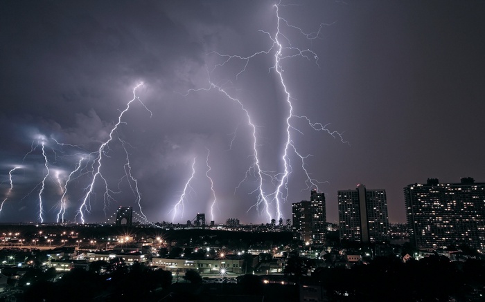 Cityscape at night with multiple lightning strikes
