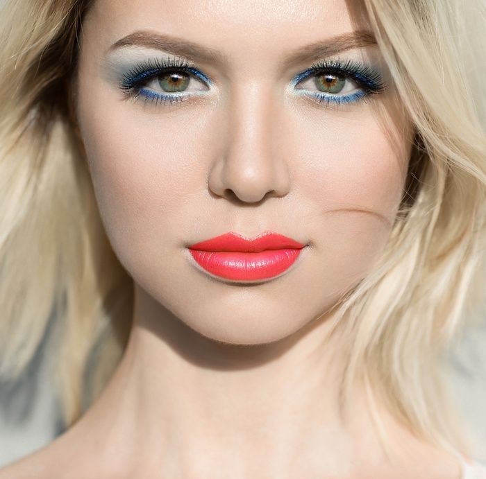 Portrait of a blonde woman with blue eyeshadow and red lipstick