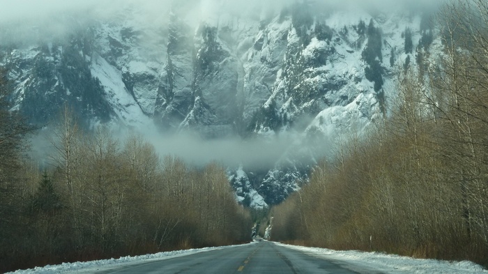 Road through a snowy mountain landscape with trees