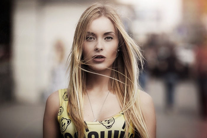 Blonde woman with windblown hair in a yellow top