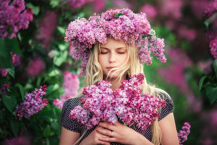 Woman with a wreath of lilacs and a bouquet
