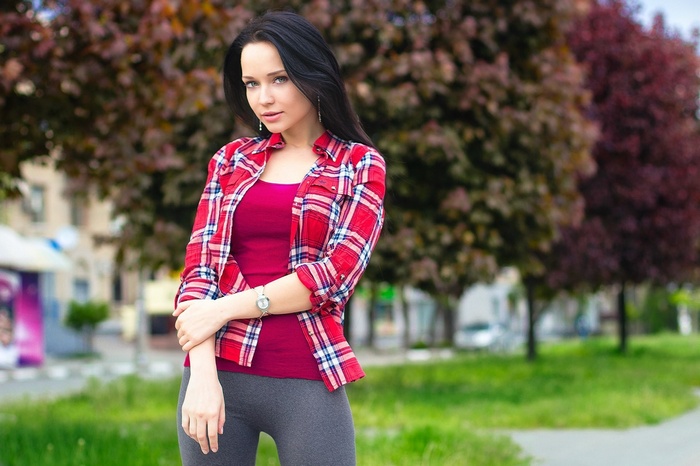 Angelina Petrova posing outdoors in a plaid shirt
