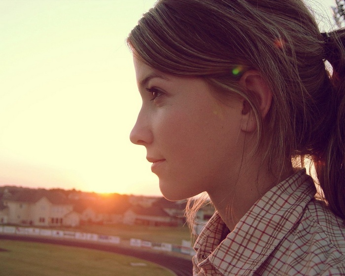 Woman in plaid shirt looking at sunset