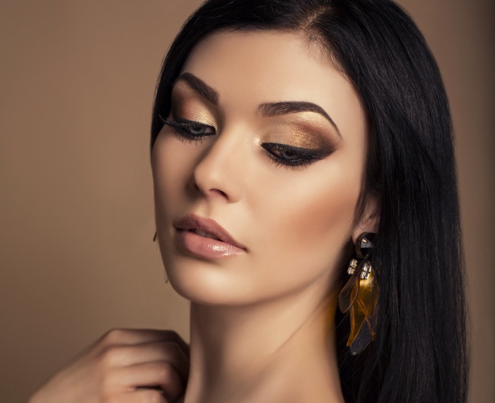 Woman with dark hair and dramatic makeup