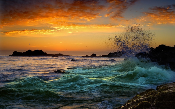 Ocean waves crashing on rocks at sunset