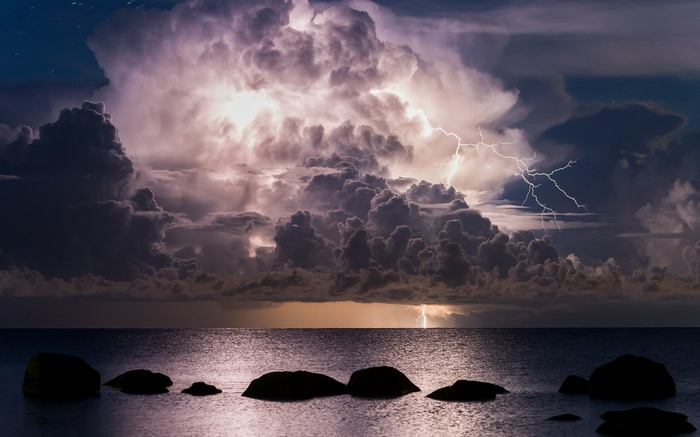 Lightning strikes over the sea during a night storm