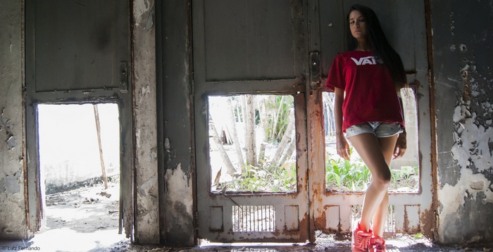 Woman in Vans t-shirt and jean shorts in doorway