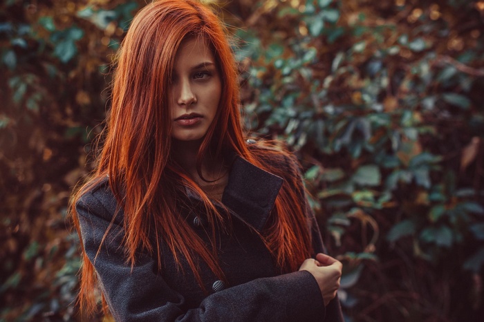 Woman with long red hair wearing a grey coat