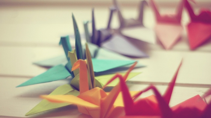 Colorful origami paper cranes arranged in a row