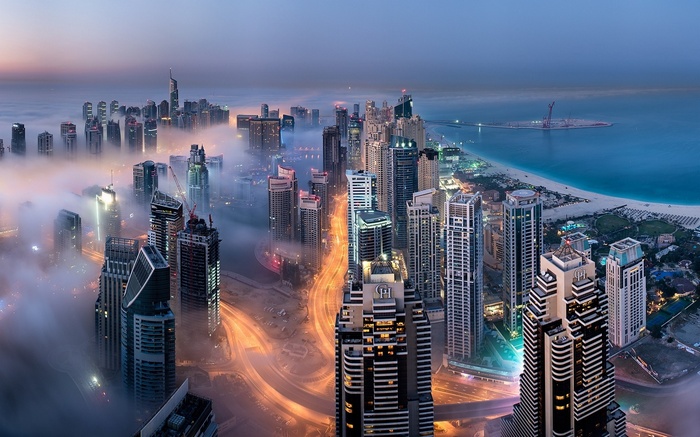Dubai skyscrapers shrouded in mist over the bay at dusk