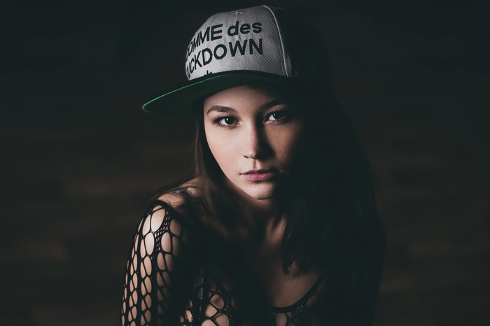 Woman wearing a cap and fishnet top