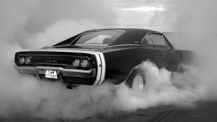 Black Dodge Charger doing a burnout in smoke