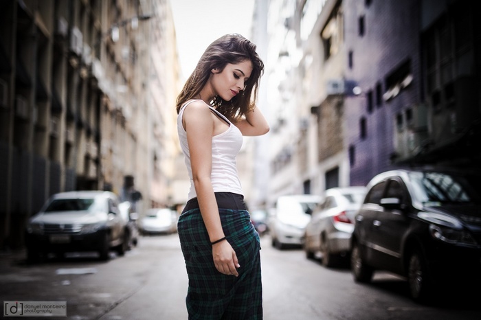 Woman in plaid skirt on a city street with cars