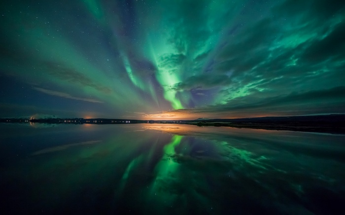 Aurora Borealis reflected in a calm lake at night
