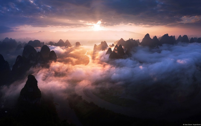 Misty mountains and river at sunrise