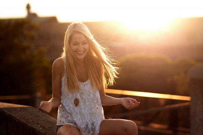 Blonde woman laughing in sunlight