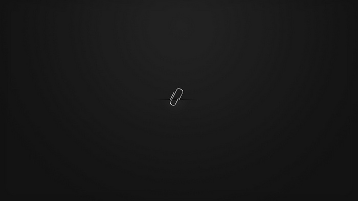 A single paperclip on a black background