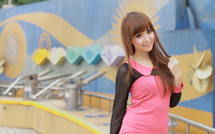 Asian woman in pink dress posing outdoors