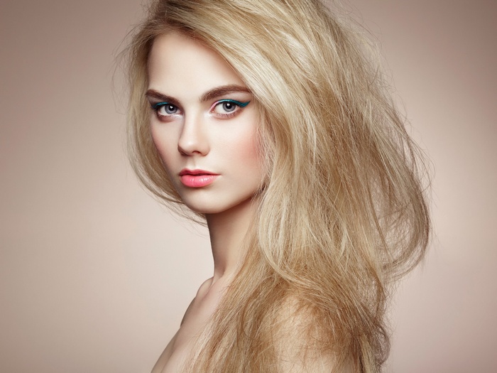 Blonde woman with striking makeup and flowing hair
