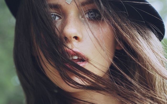 Close-up of a young woman's face with hair blowing