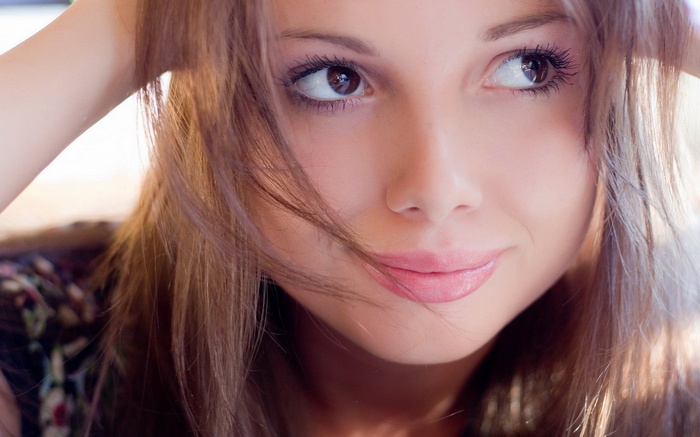 Woman with brown hair and brown eyes smiling