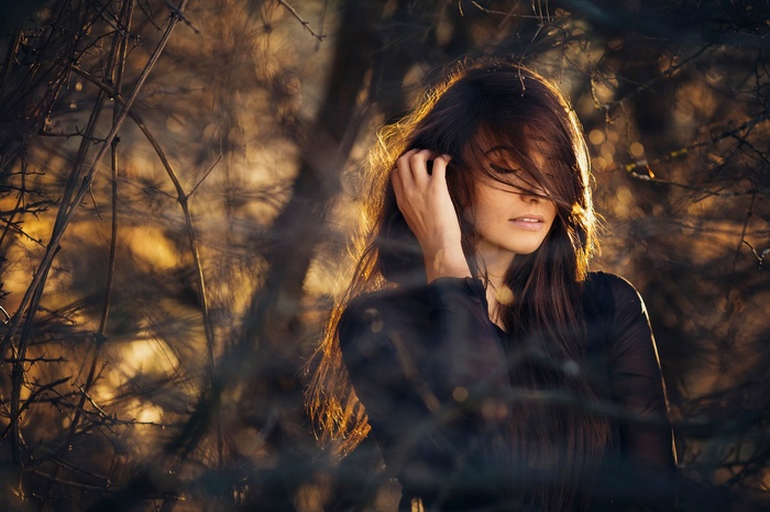 Woman with hair in face among twigs