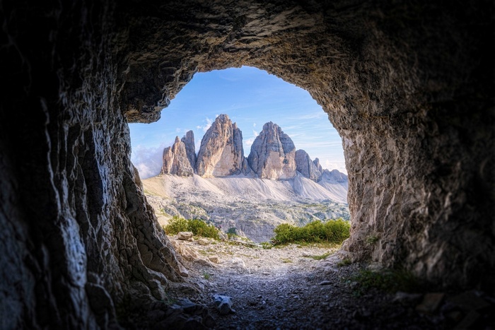 View of Tre Cime di Lavaredo mountains from a cave