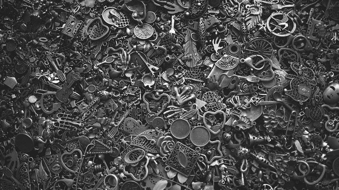 A pile of metal charms including keys, hearts, and musical instruments