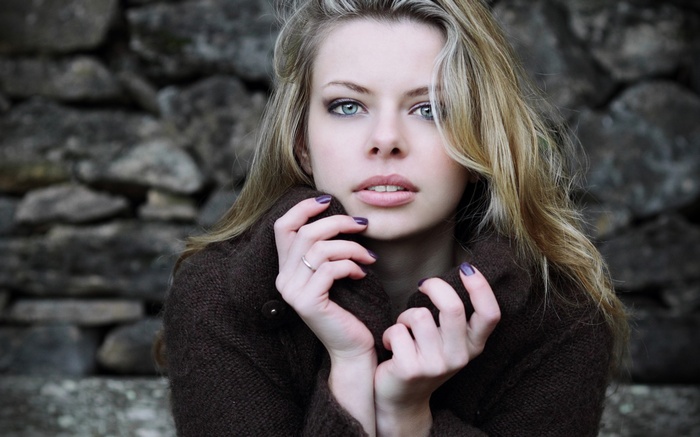 Woman with blonde hair and blue eyes wearing a sweater
