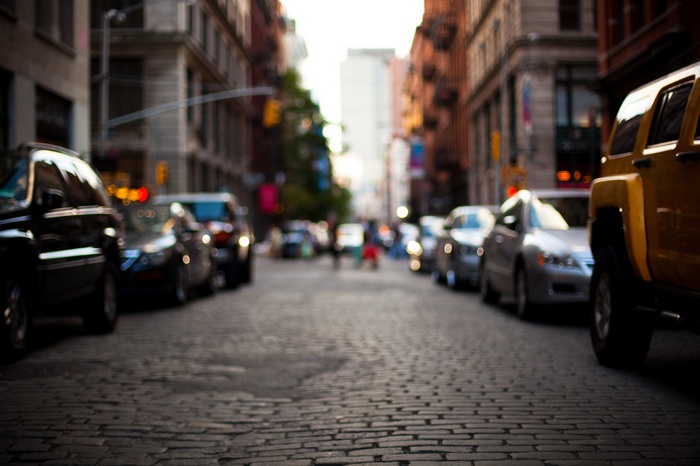 Blurred city street with parked cars