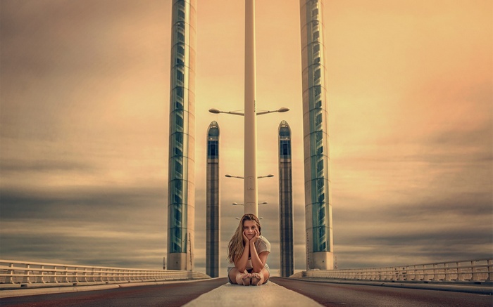 Woman sitting on Bordeaux bridge with towers