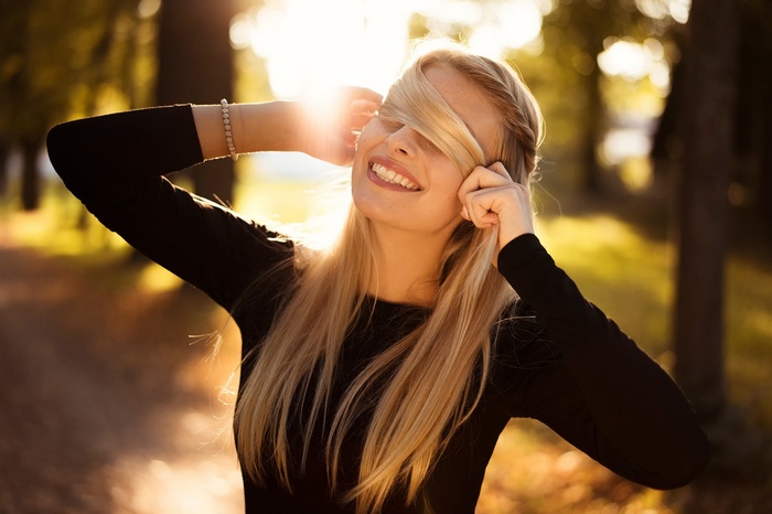 Blonde woman with hair covering her face