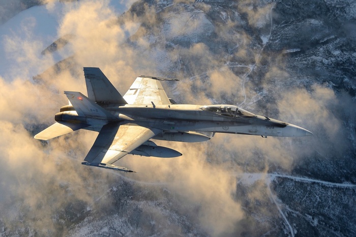 McDonnell Douglas FA-18 Hornet flying over snowy mountains