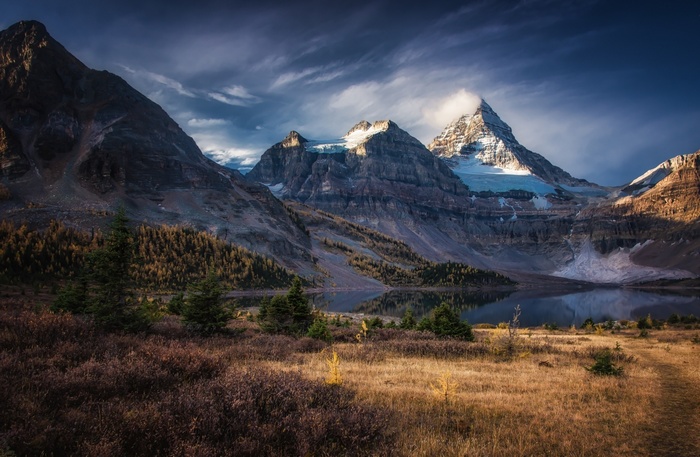 Snowy mountain peaks reflected in a lake during fall