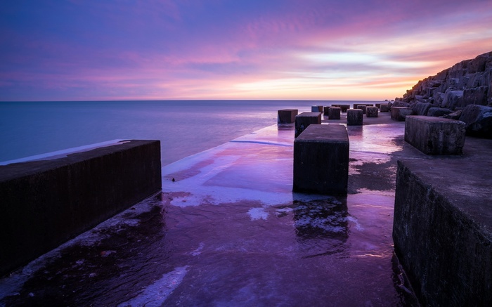 Concrete blocks on a pier at sunset
