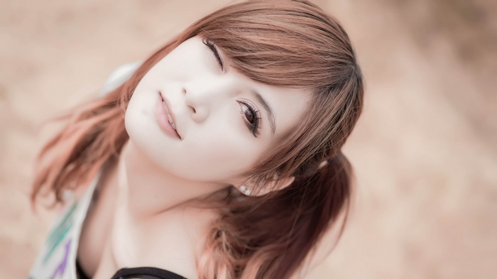 Asian model with auburn hair winks