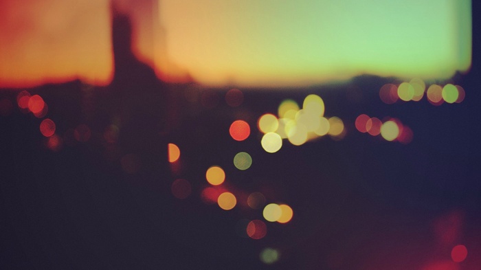 Blurred cityscape with bokeh lights at sunset