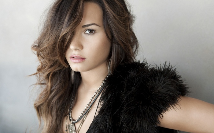 Demi Lovato with dark hair and fur vest