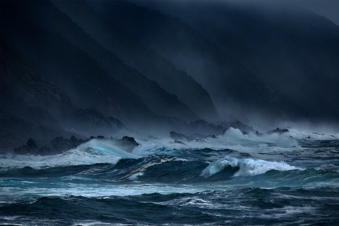 Stormy sea with waves crashing against rocky shore
