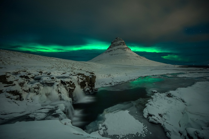 Kirkjufell mountain and waterfall under aurora borealis