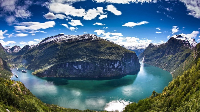 Geiranger Fjord landscape with snow-capped mountains and boats