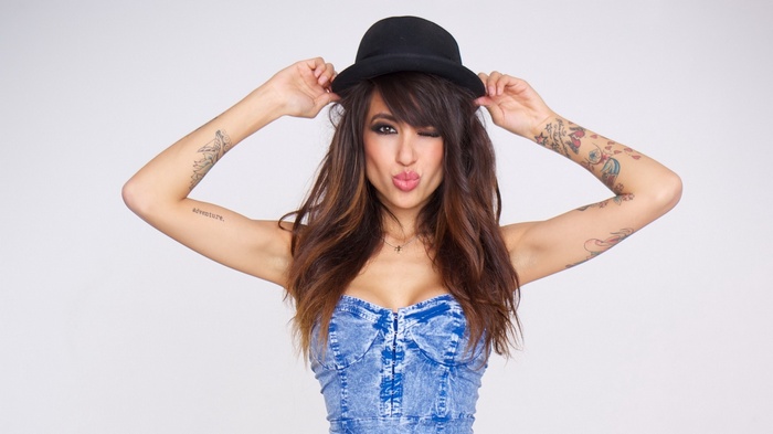 Alie Layus wearing a hat and a denim top