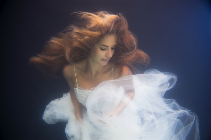 Woman in white dress underwater
